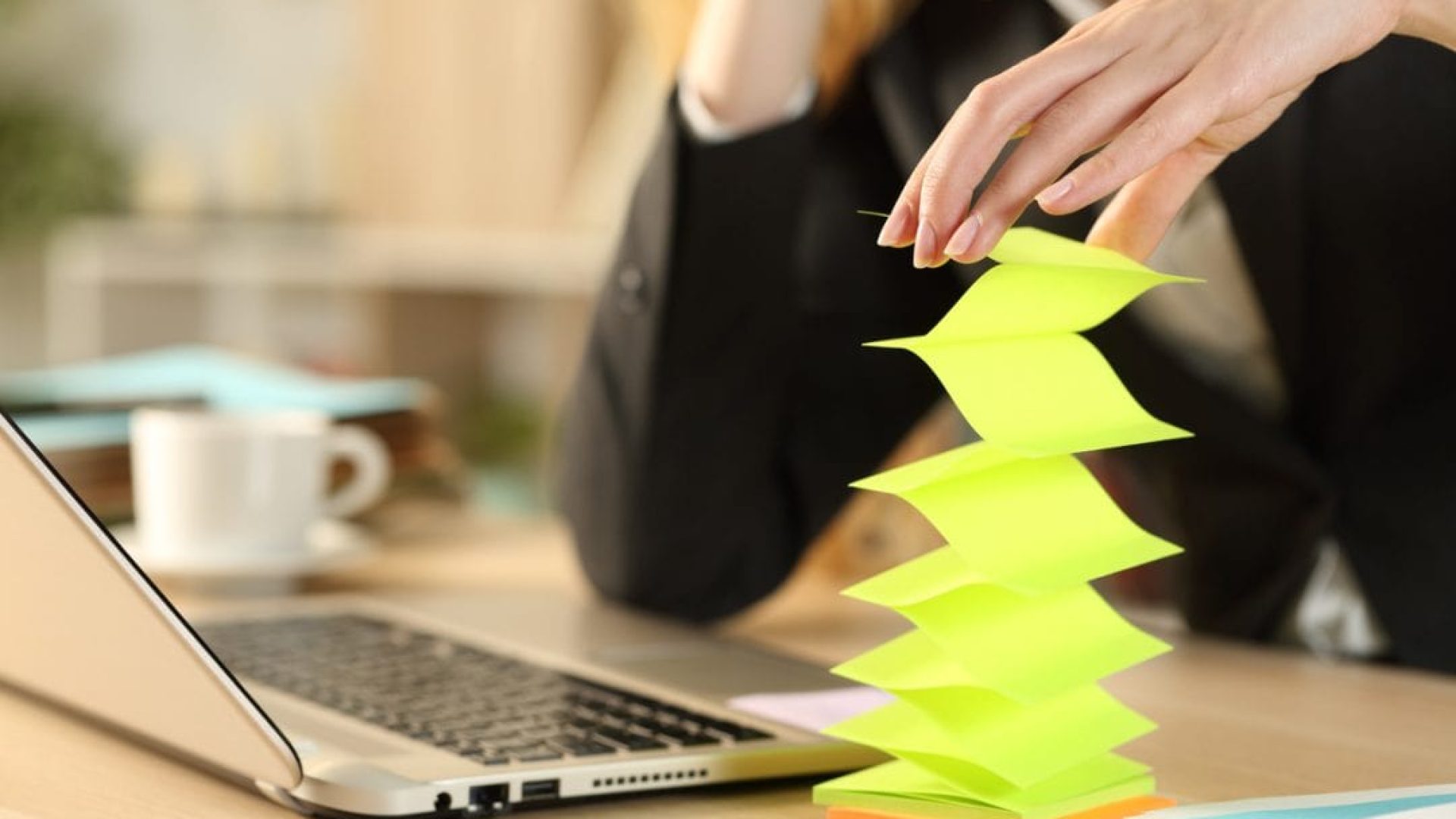 Bored lazy entrepreneur woman hands wasting time with post notes sitting on a desk