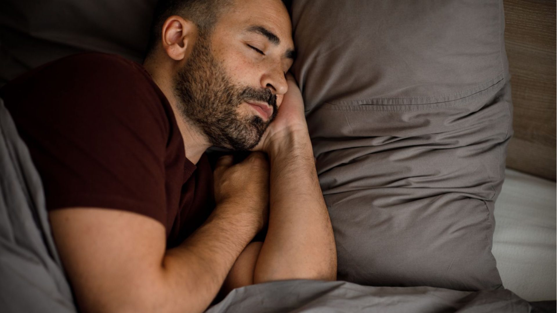 calm-young-man-with-beard-sleeps-bed-soft-pillow-blanket-bedroom-interior-3